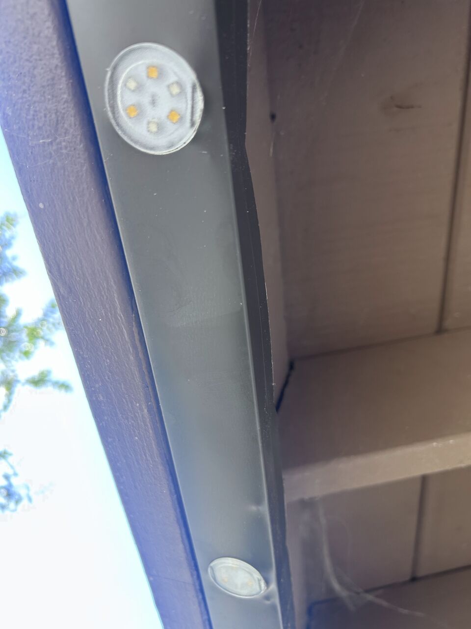 Daylight close-up of the slim X LIGHTS track and lights mounted along a dark fascia