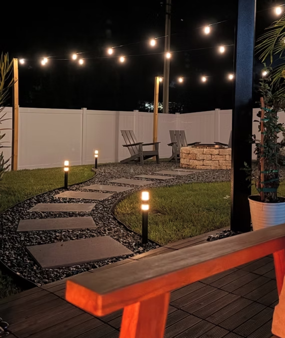 Outdoor patio with overhead bistro lights and landscape accents